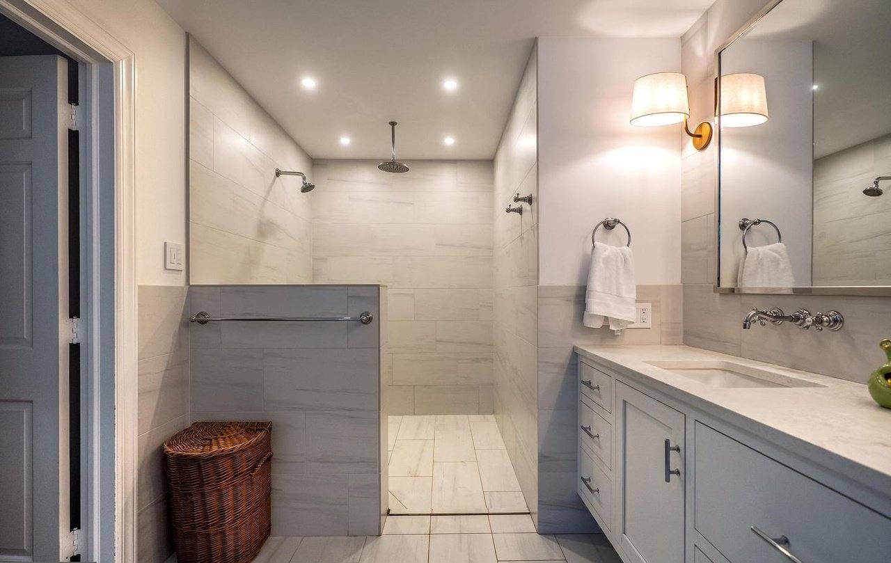 Primary bathroom with a large walk-in tile shower and double vanity