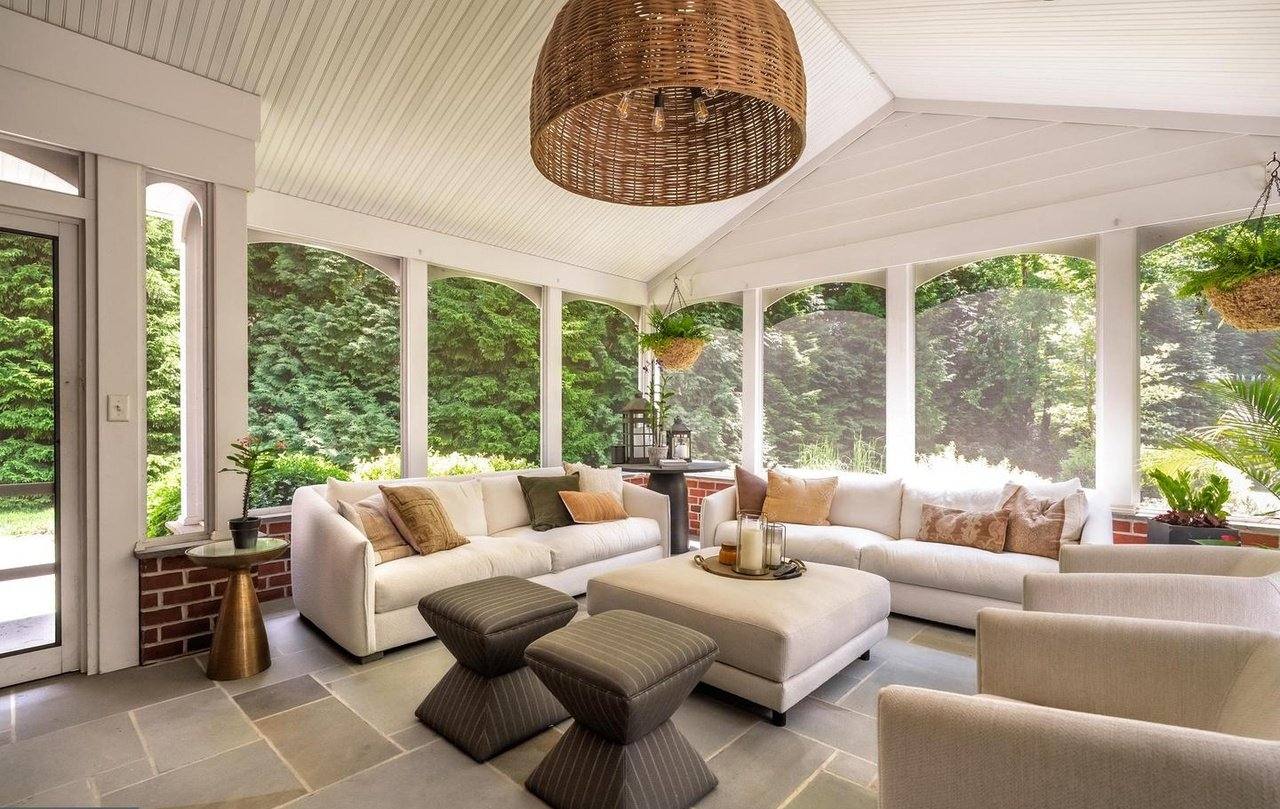 Screened porch furnished as an outdoor living room overlooking the rear grounds